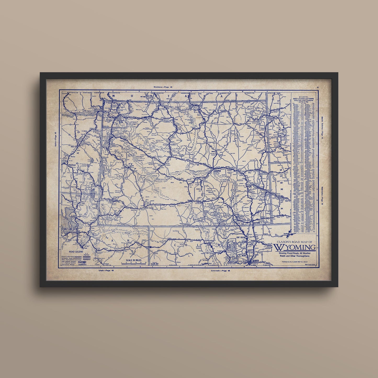 The image is a framed vintage map of Wyoming, depicting the state's roads and railroads in a detailed and intricate manner.