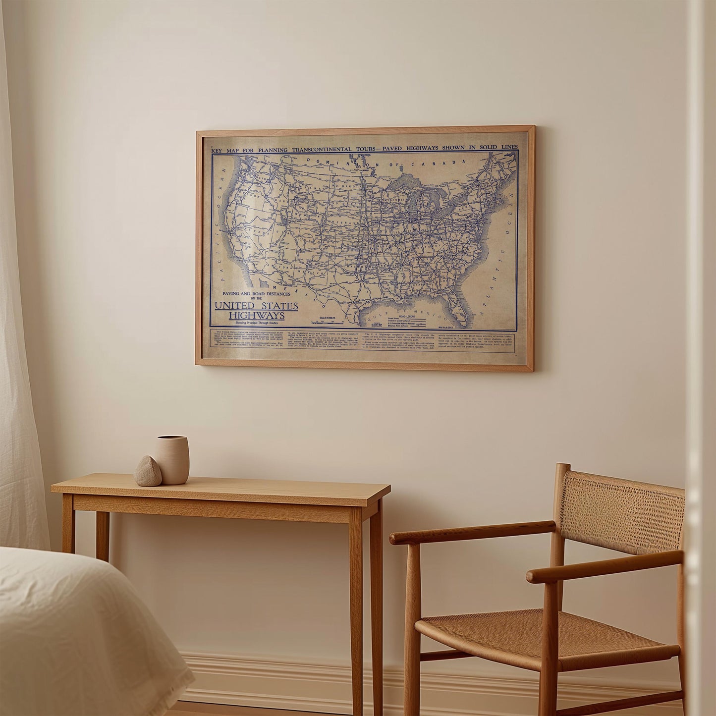 a framed map of the United States hanging on a wall above a small wooden table and chair in a room.