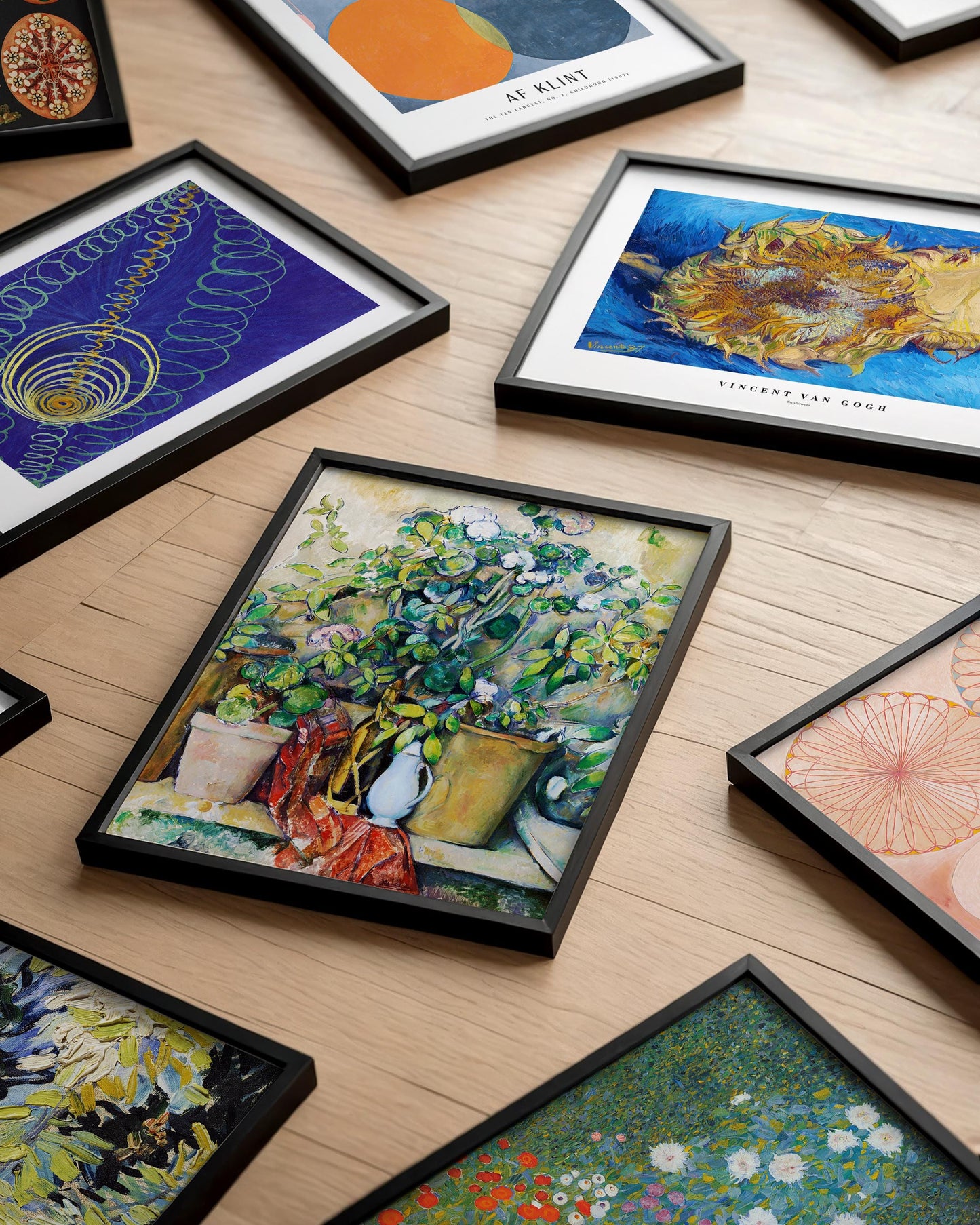 a collection of framed artworks displayed on a wooden surface.