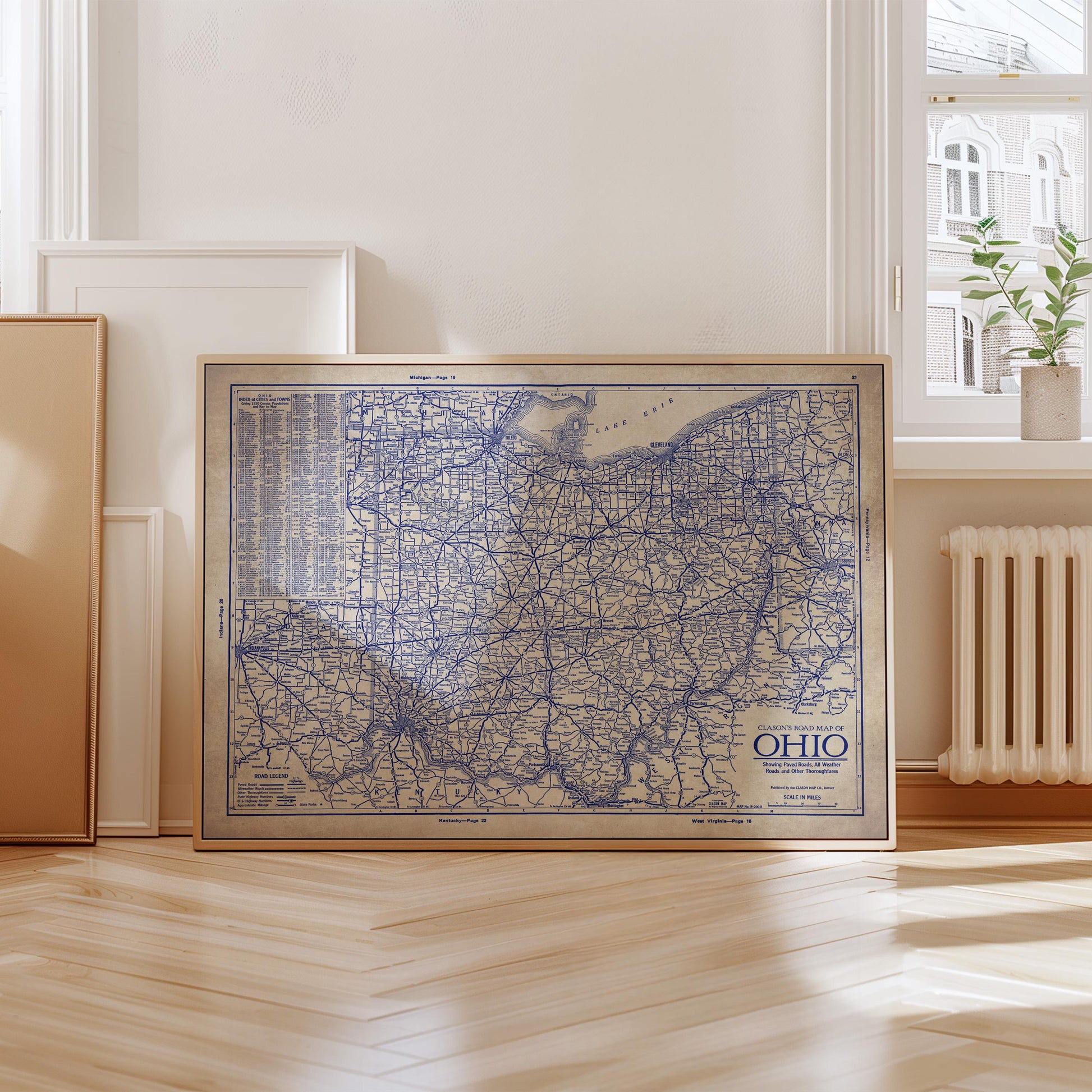 a large framed map of the United States, specifically the state of Ohio, displayed on a wooden floor in a room with a window and a radiator.