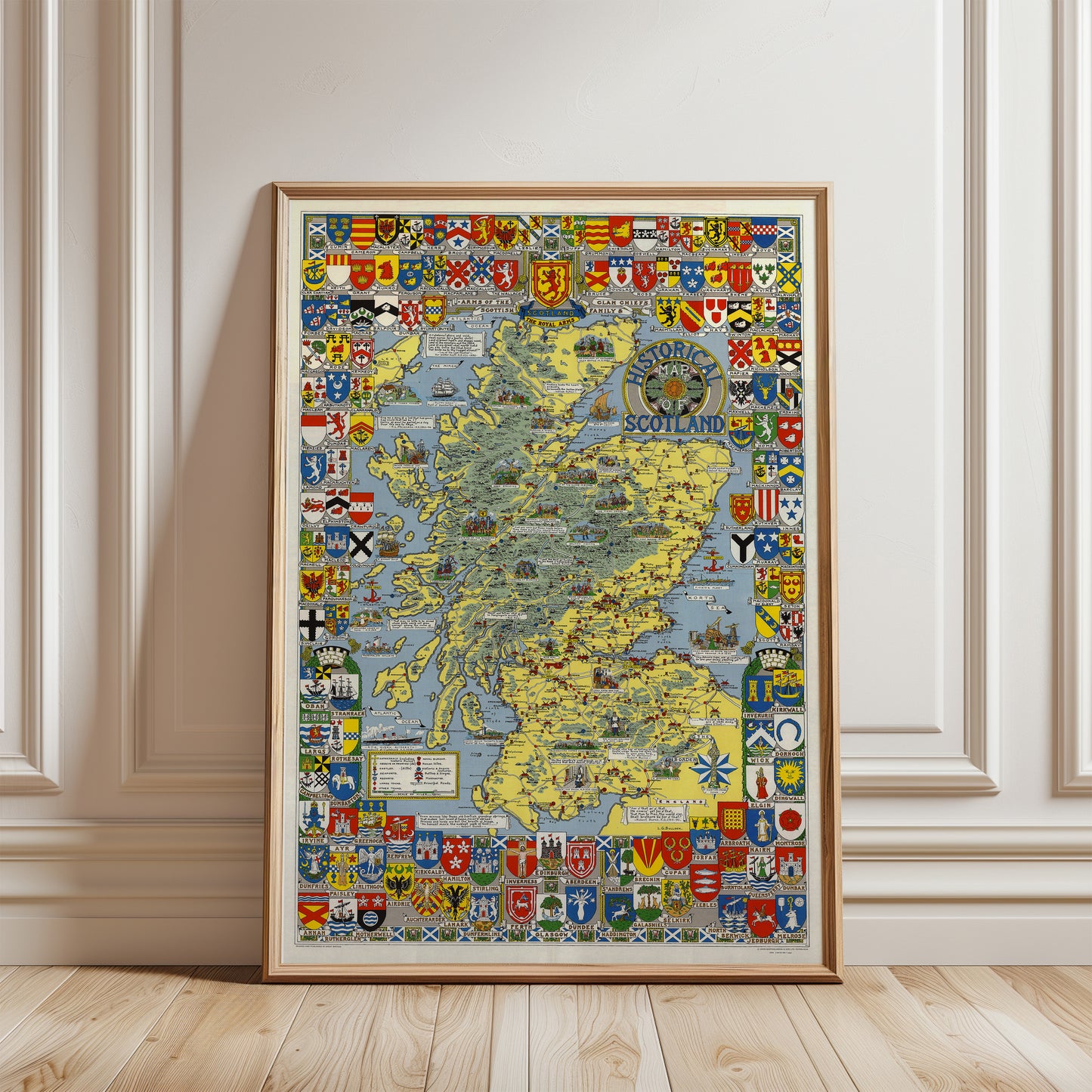 The image is a framed map of Scotland, featuring various symbols and coat of arms from different regions of the country.