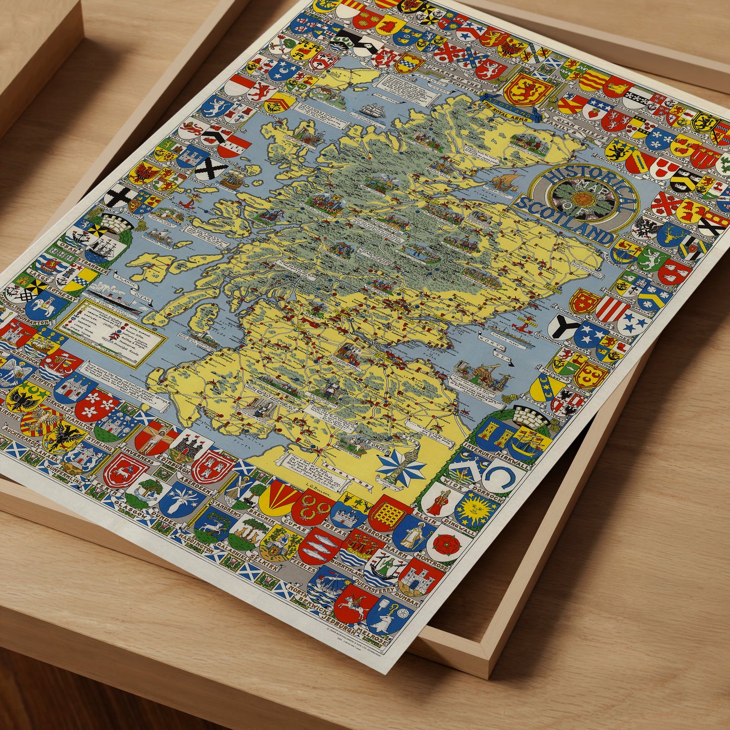 The image is a colorful and detailed map of Scotland, featuring various symbols and coat of arms from different regions of the country.