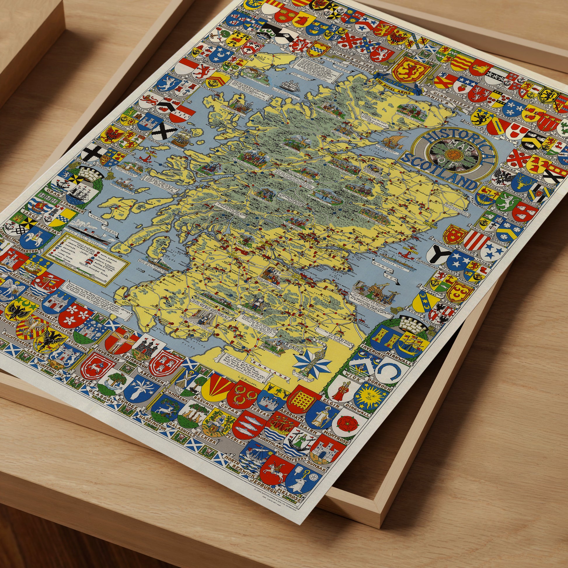 The image is a colorful and detailed map of Scotland, featuring various symbols and coat of arms from different regions of the country.