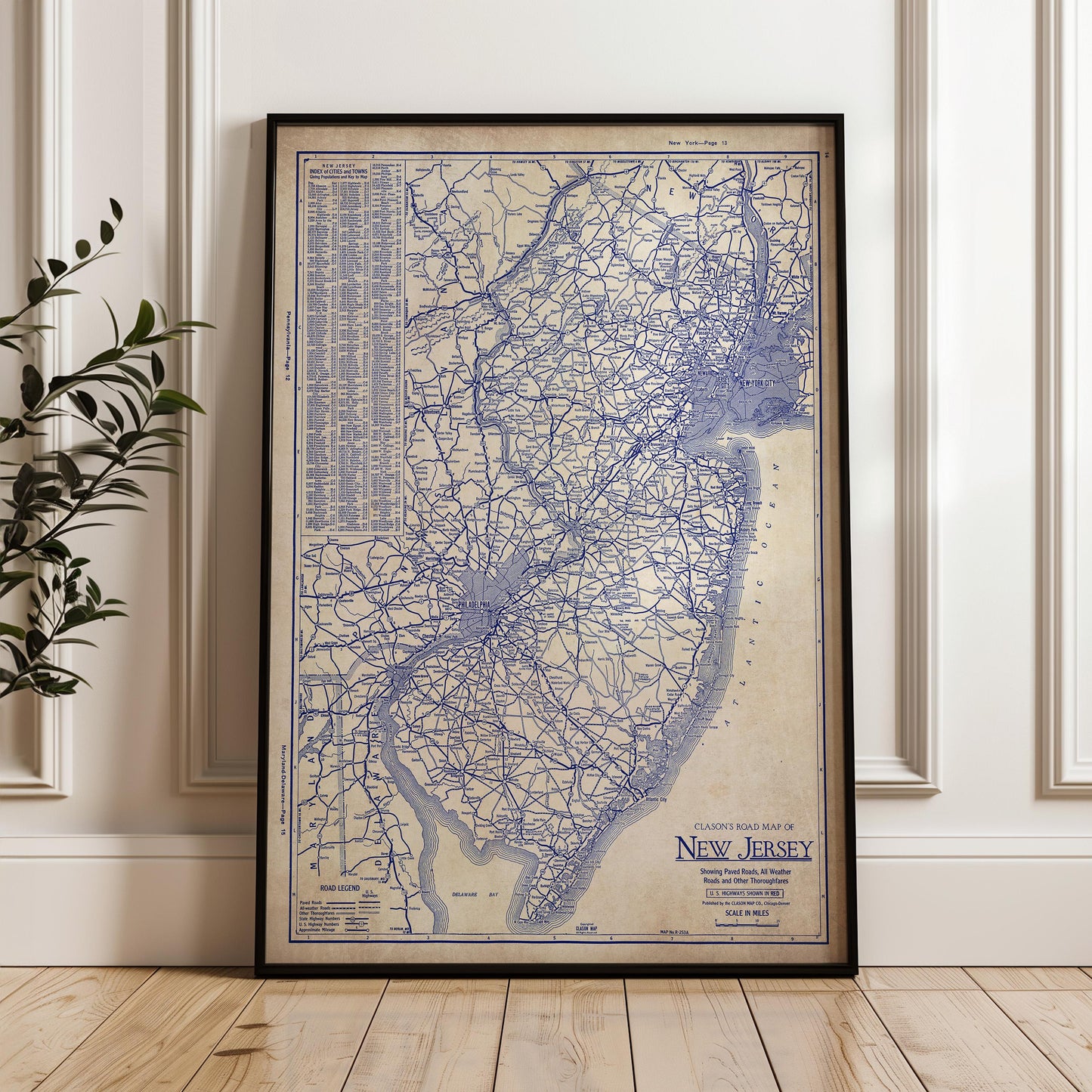 a framed vintage map of New Jersey, with intricate blue lines and labels indicating the state's roads and highways.