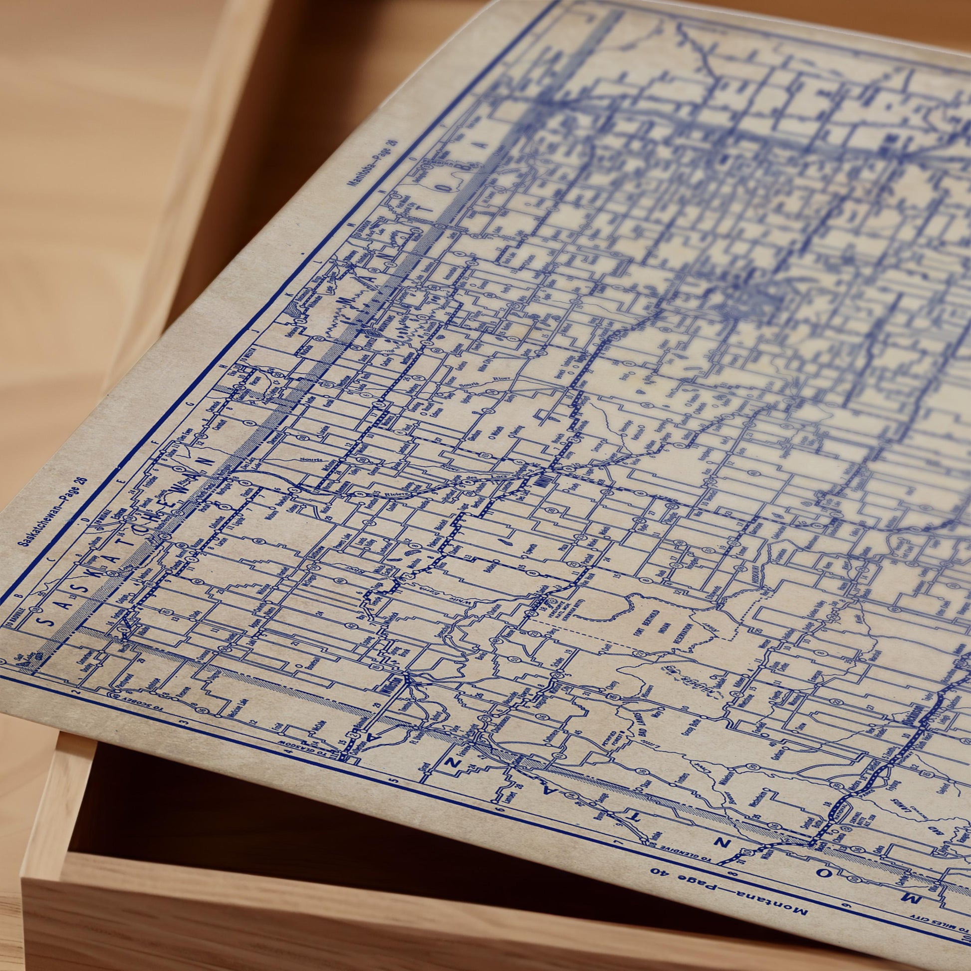 a close-up view of a map with intricate blue lines and markings, placed on a wooden surface.