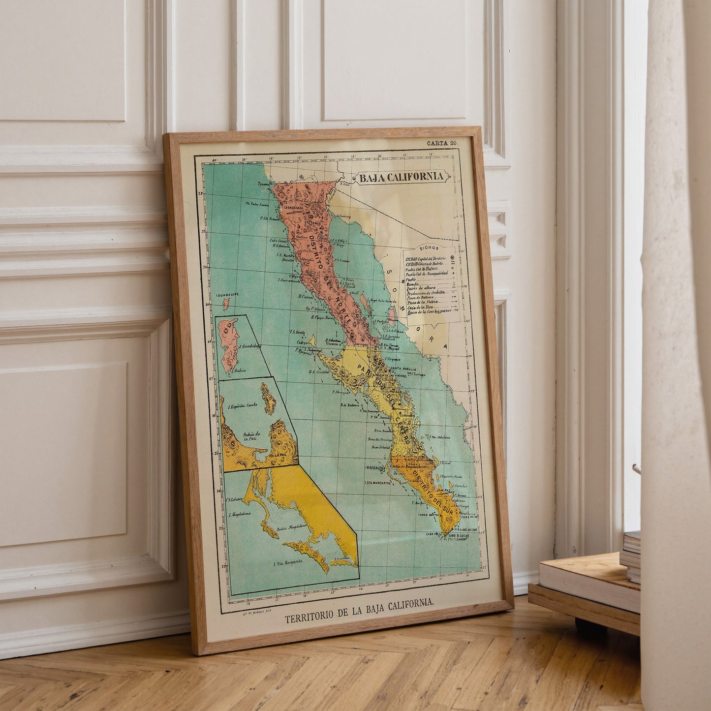 A framed vintage map of California, titled "CORTANA", is leaning against a white wall in a room.