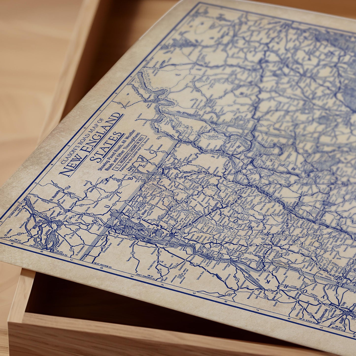 a close-up view of a vintage map of New England, with intricate blue lines and markings representing the region's roads and highways.