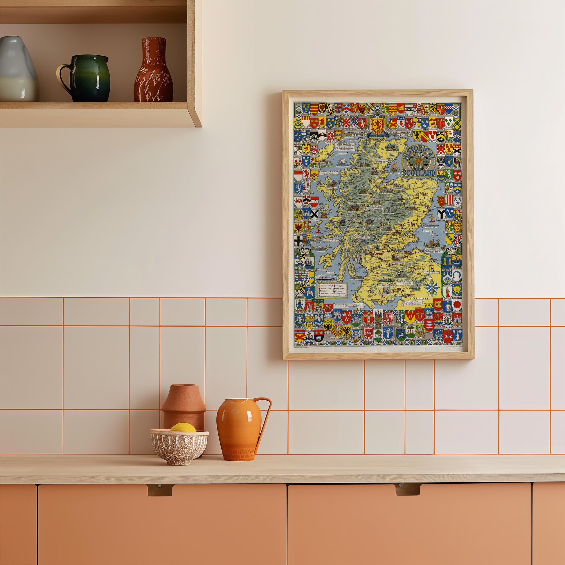 a kitchen counter with various items on it, including a framed map, a bowl, a pitcher, and a vase.