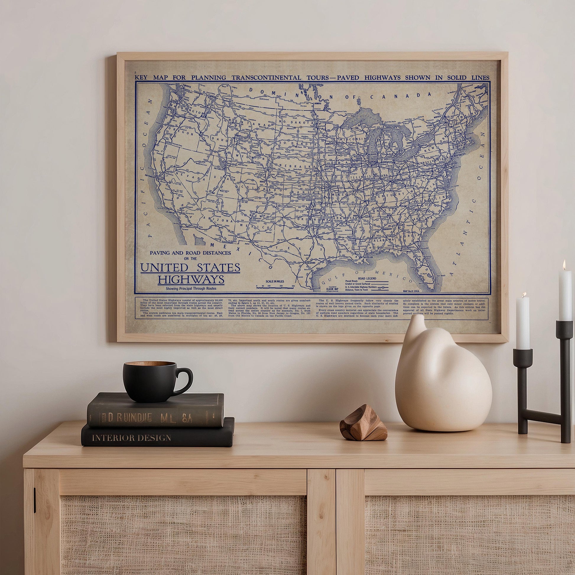 a framed map of the United States highways, with a bookshelf and various decorative items below it.