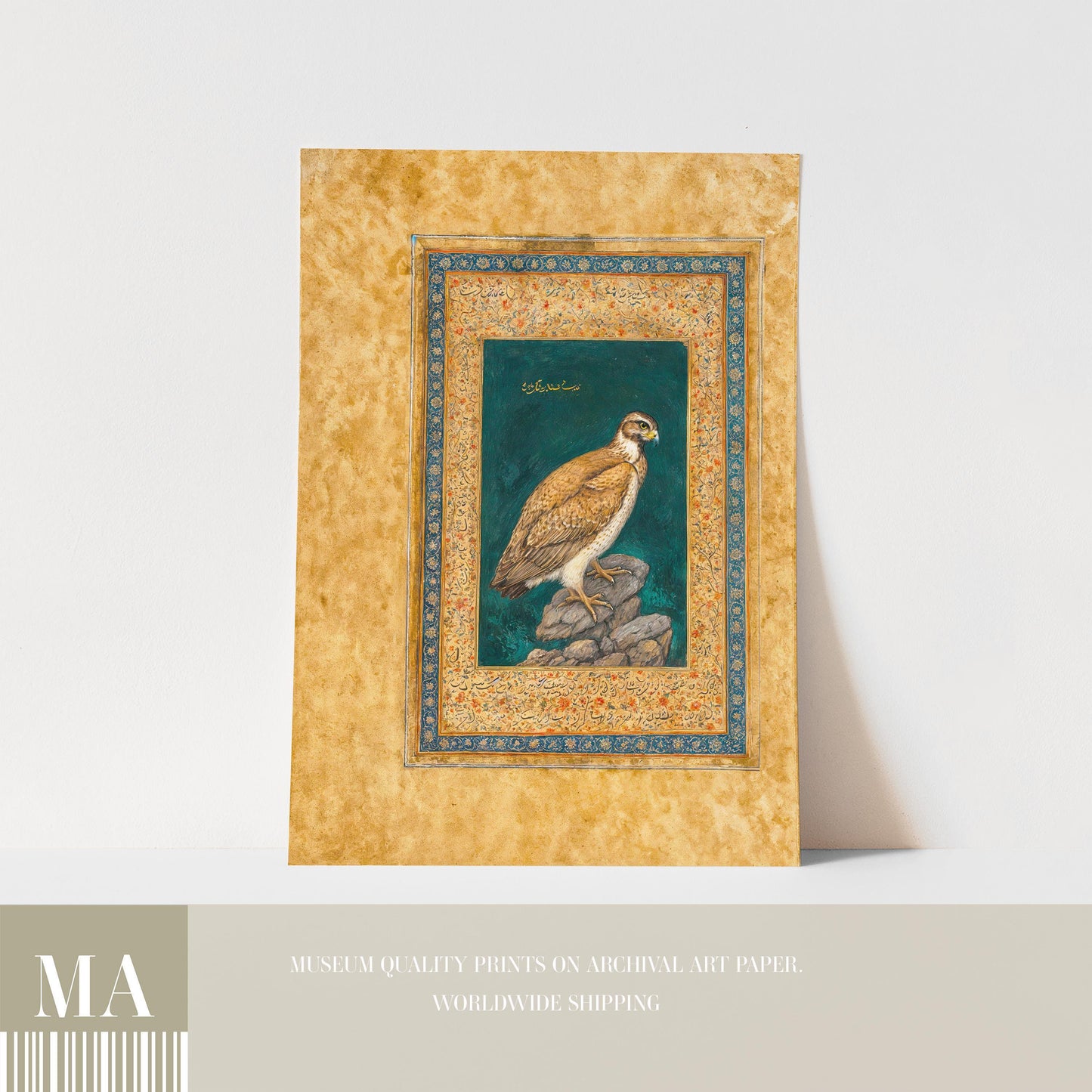 The image is a framed print depicting a bird, likely a hawk or falcon, perched on a rock. The print is framed in a decorative golden border and is displayed on a white surface.