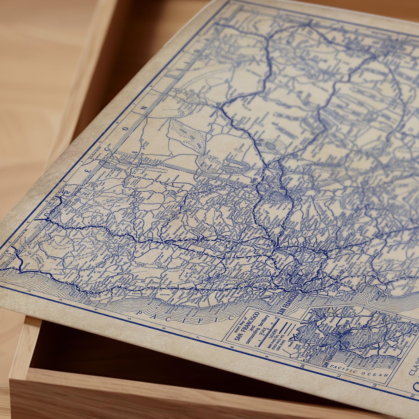 a close-up view of an old map with intricate blue lines and markings, resting on a wooden surface.