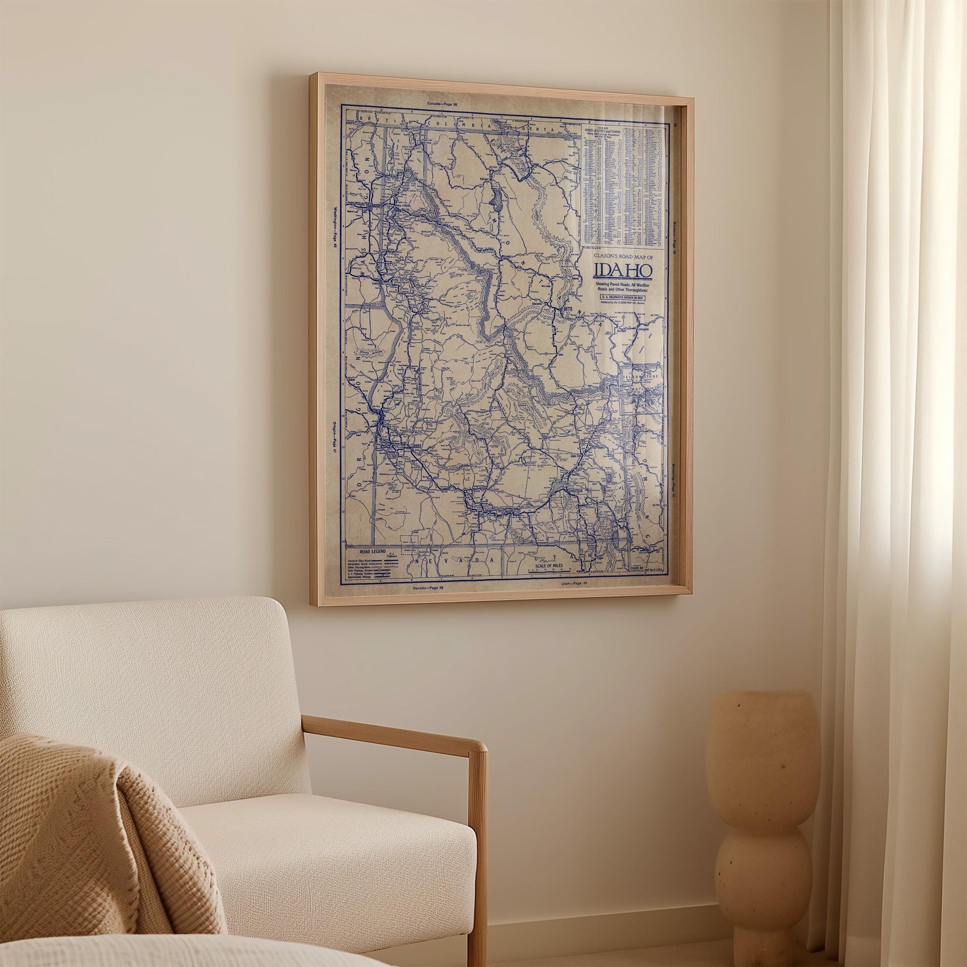 a framed map of Idaho hanging on a wall in a room with a white sofa and a small sculpture.
