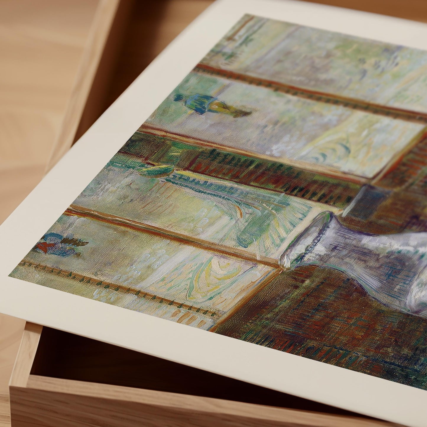 The image is a close-up of a framed painting on a wooden surface, with a wooden box visible in the background.