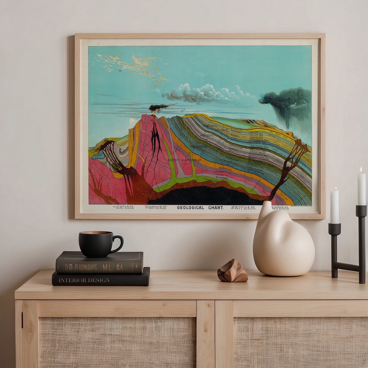 a framed painting of a colorful, abstract landscape with a mountain range and a blue sky with clouds. The painting is hanging on a wall above a wooden shelf with various items on it, including a stack of books, a ceramic vase, and a small sculpture.