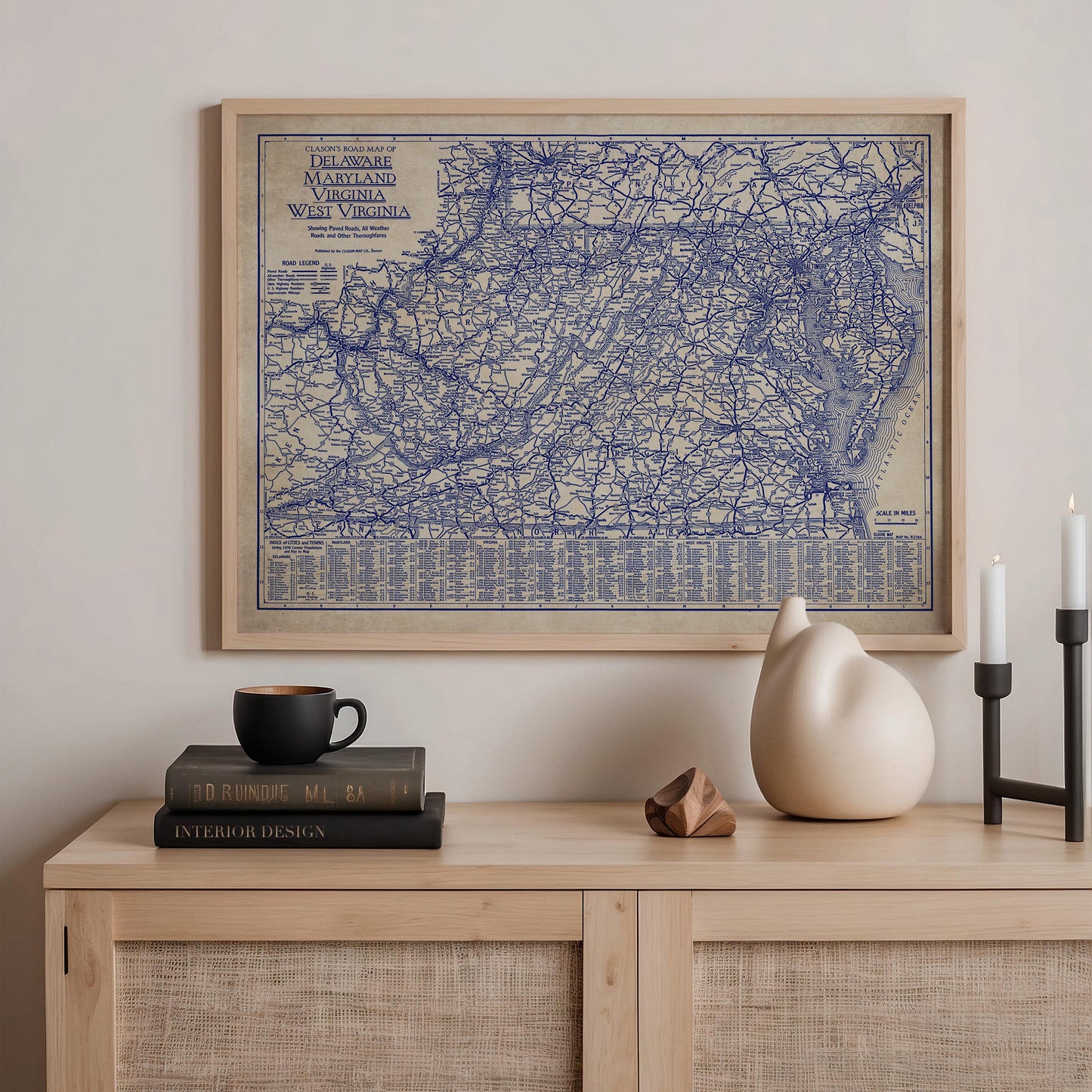 a framed map of the eastern United States, including Virginia, West Virginia, and Maryland, hanging on a wall above a wooden shelf with various items on it.