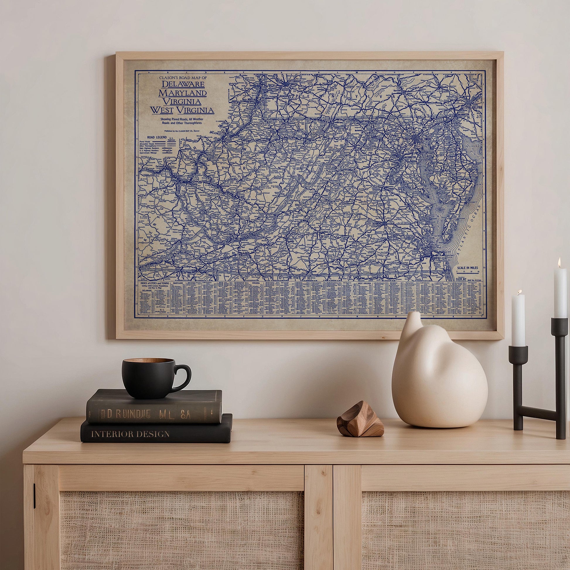 a framed map of the eastern United States, including Virginia, West Virginia, and Maryland, hanging on a wall above a wooden shelf with various items on it.