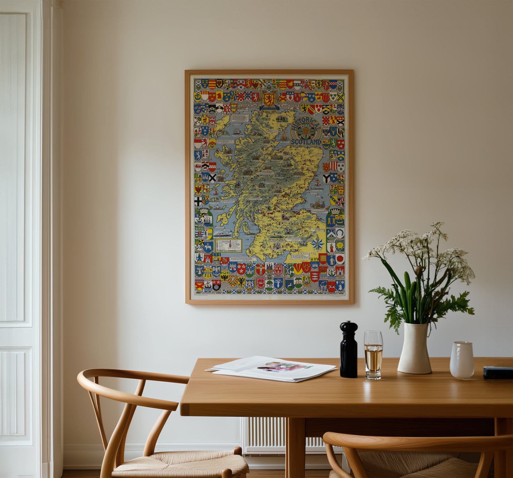 a dining room with a wooden table, two chairs, and a framed map hanging on the wall above the table.
