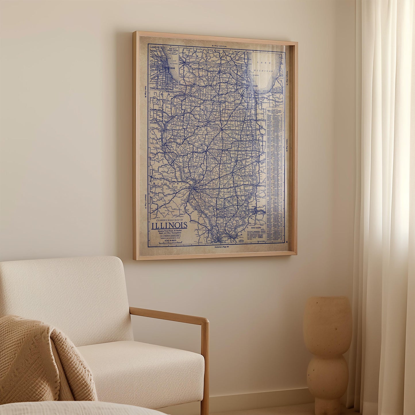 a framed map of Illinois hanging on a wall in a room with a white sofa and a small sculpture.