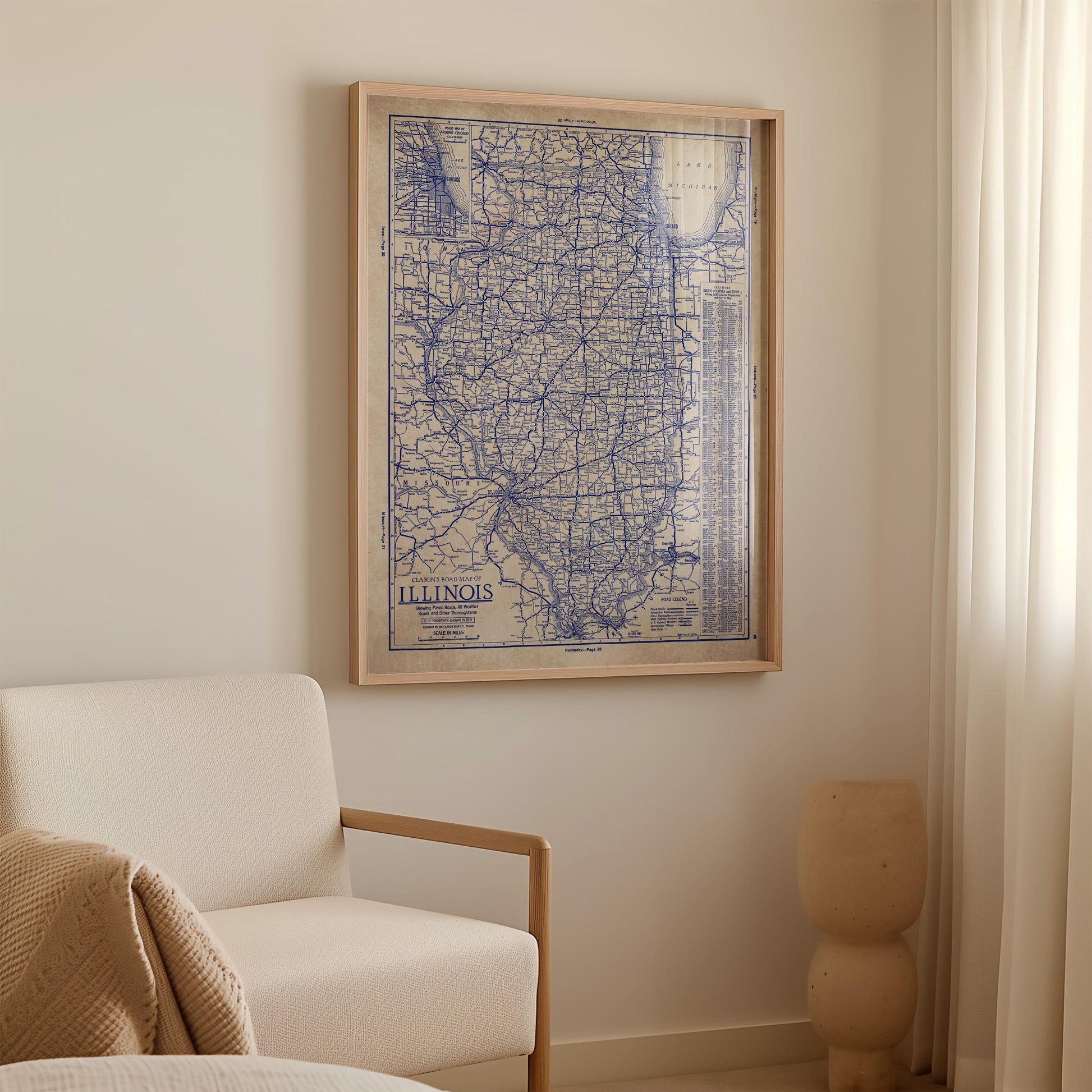 a framed map of Illinois hanging on a wall in a room with a white sofa and a small sculpture.