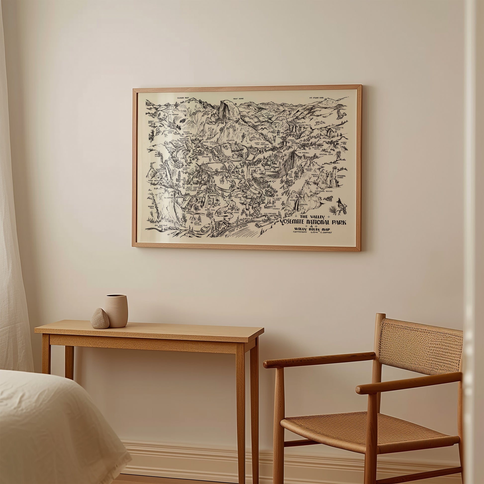 a wooden table with a small vase on it, and a wooden chair is positioned next to the table. Above the table, there is a framed map hanging on the wall.