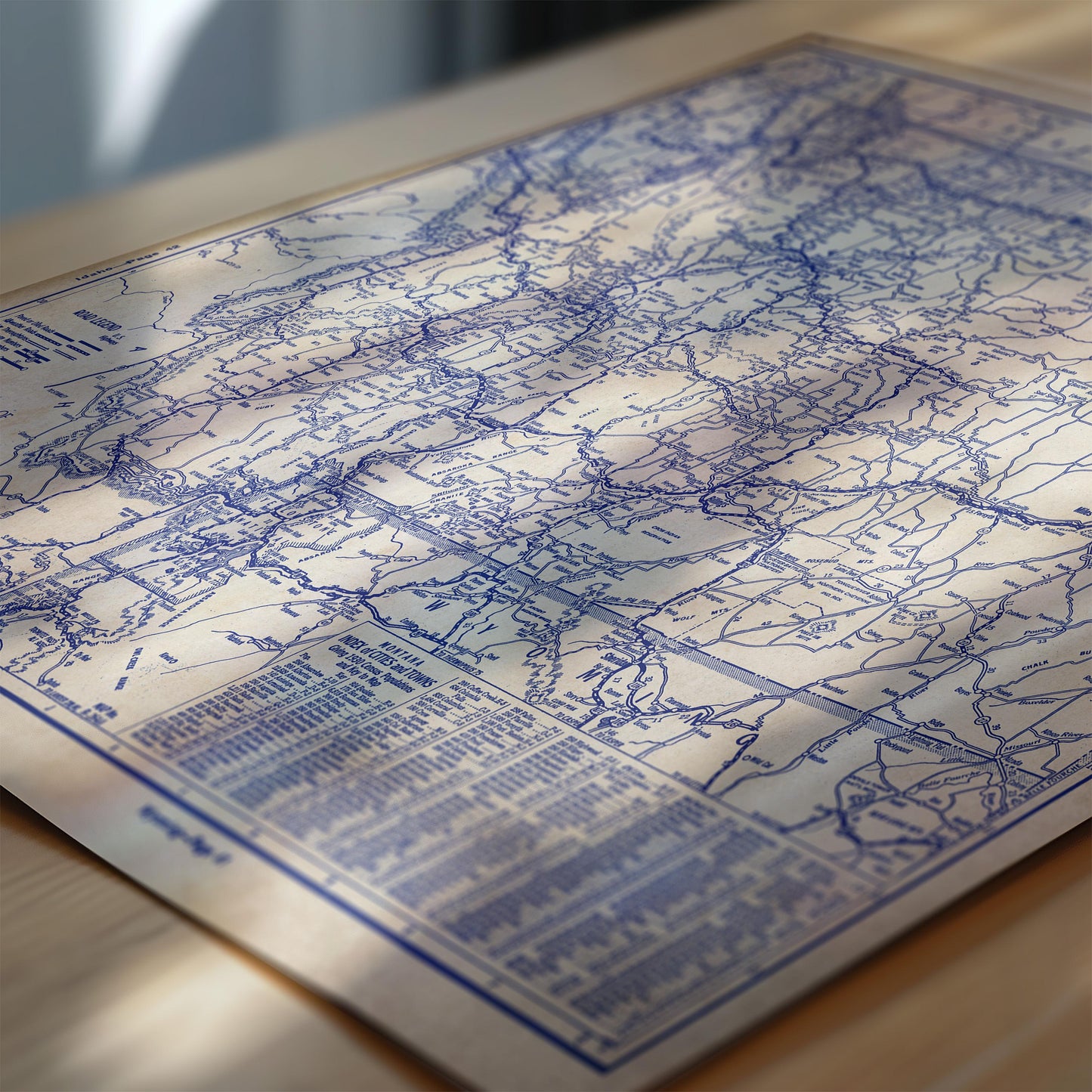 The image is a detailed map of a region, with various roads and landmarks marked on it. The map appears to be in blue and white colors, and it is placed on a wooden surface.