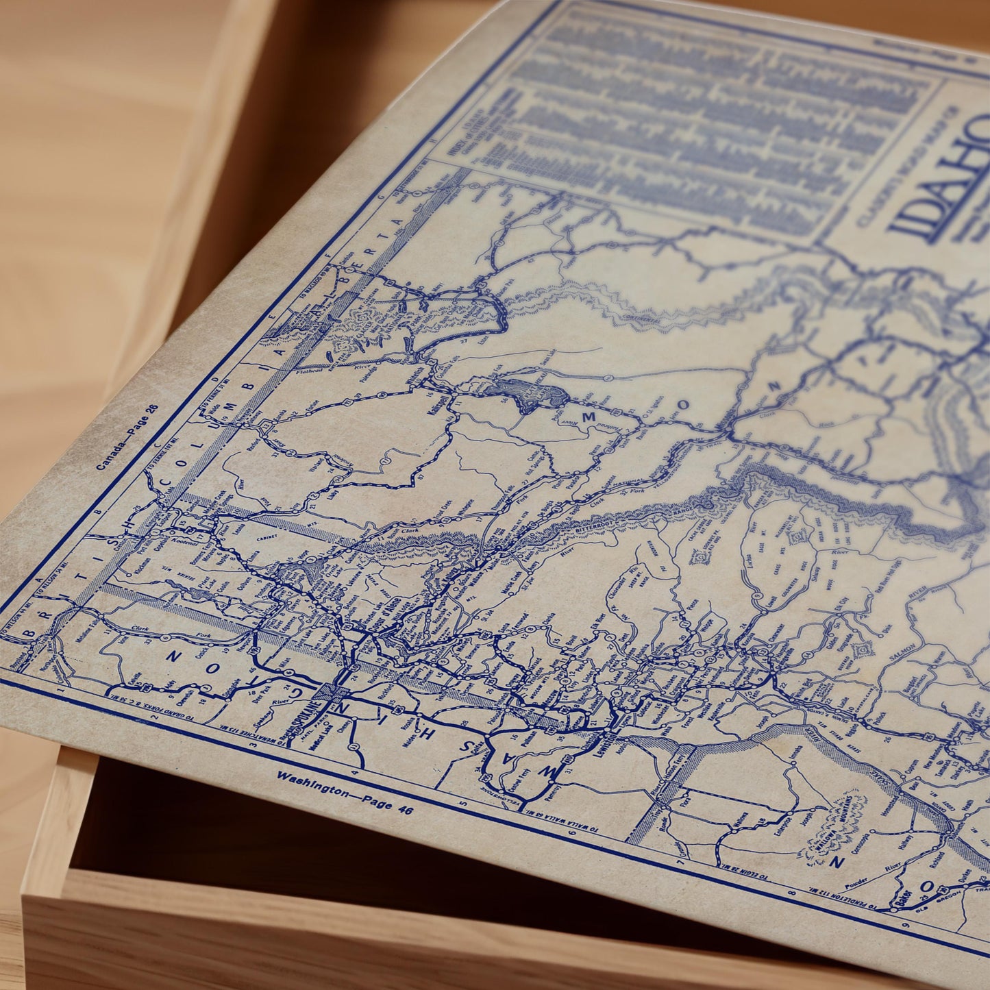 a close-up view of a map with detailed blue lines and markings, resting on a wooden surface.