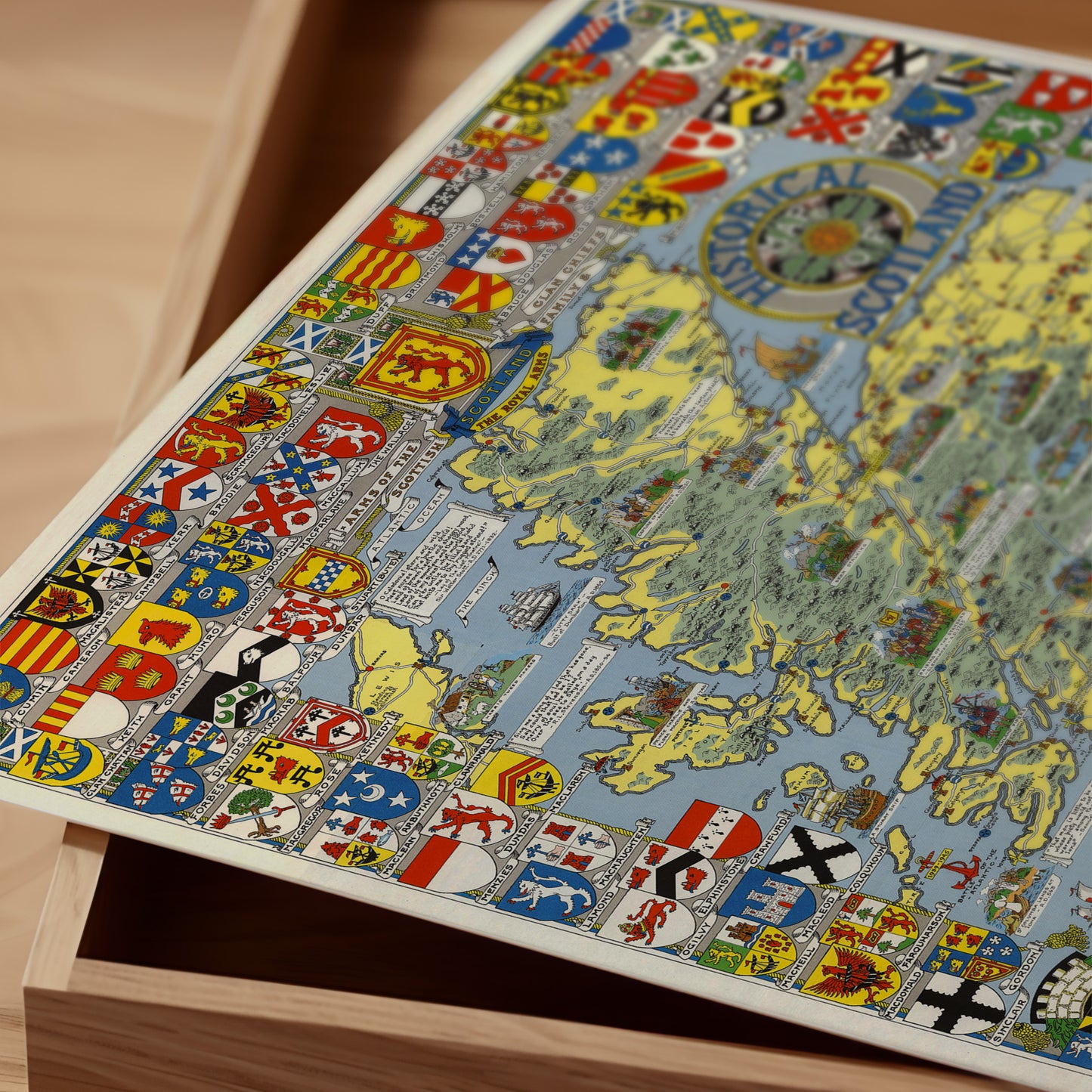 The image is a colorful and detailed map of Scotland, featuring various national symbols and coat of arms.