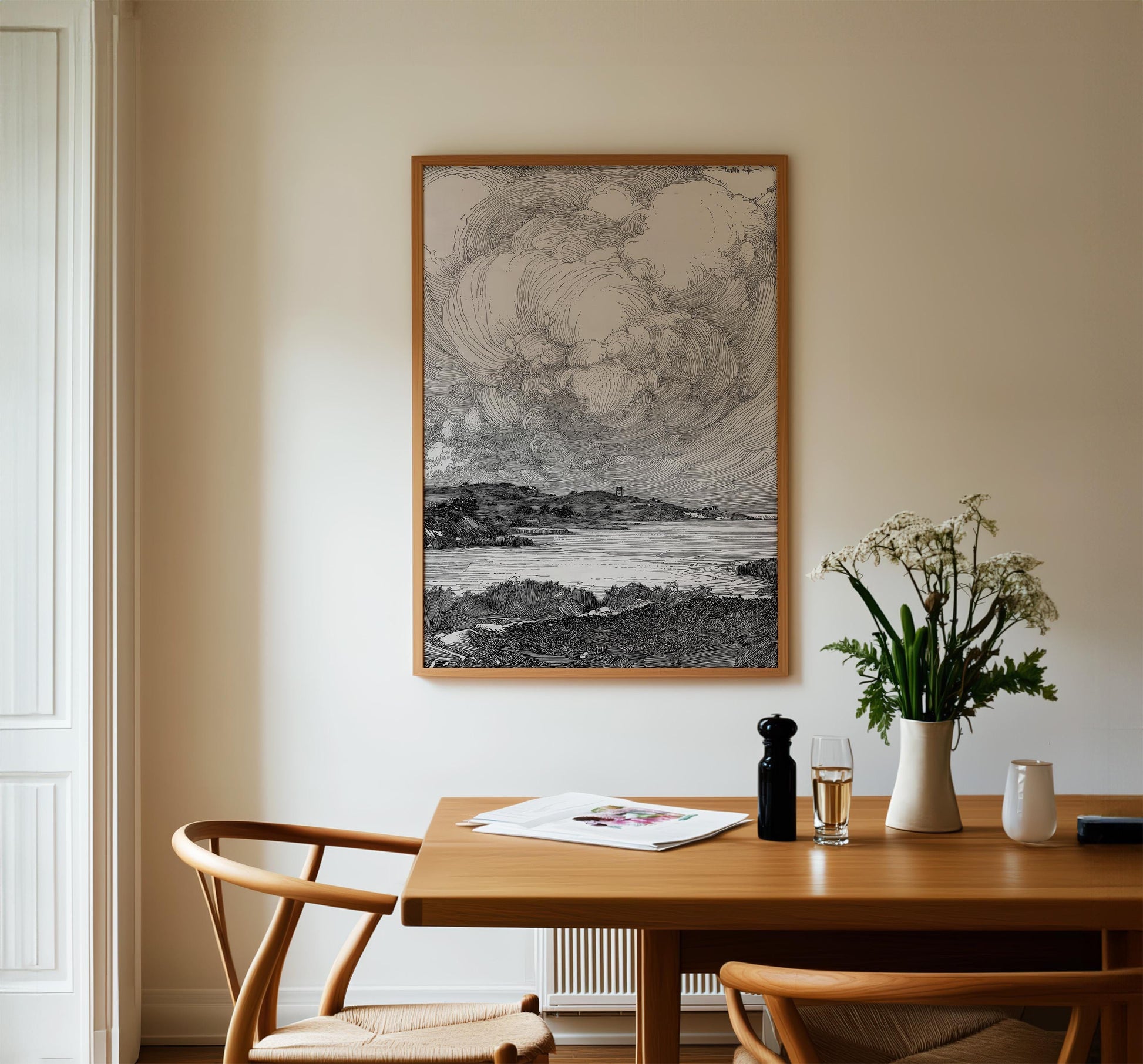 a serene indoor setting with a wooden dining table, two chairs, a framed landscape drawing on the wall, and a vase of flowers on the table.