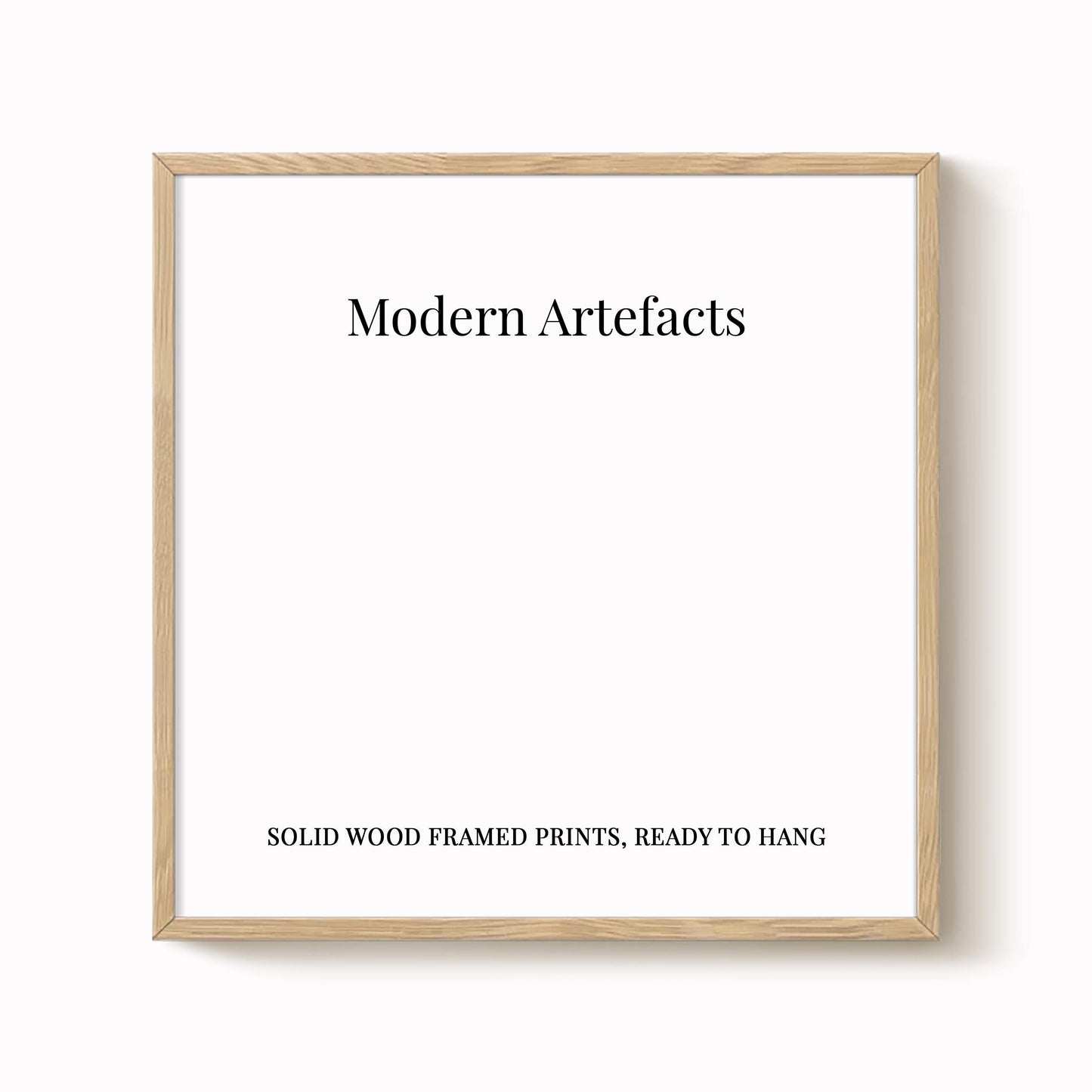The image is a square-shaped white frame with the text "Modern Artifacts" written in black at the top. Below the frame, the text reads "SOLID WOOD FRAMED PRINTS. READY TO HANG".