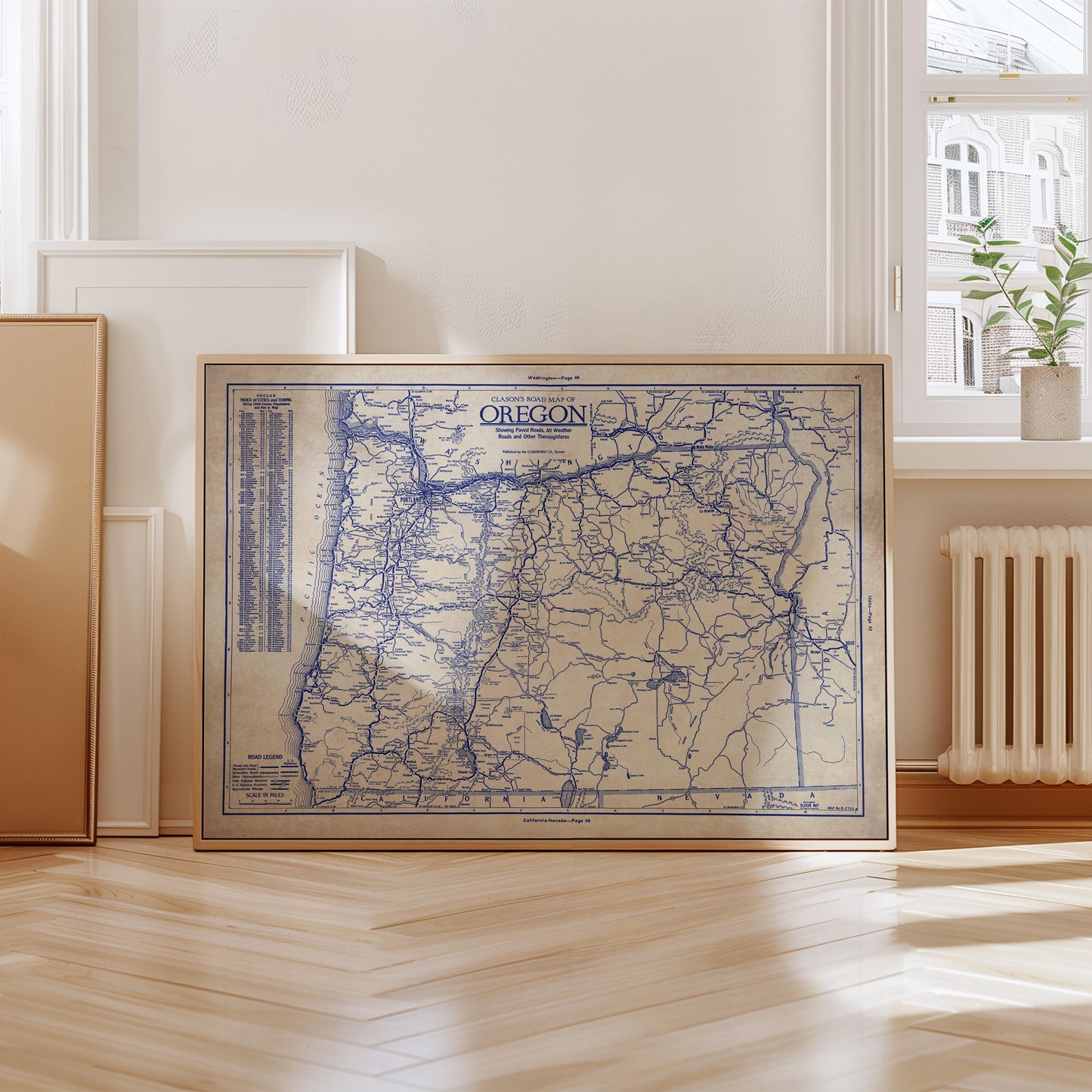 a framed map of Oregon, with a wooden floor and a window in the background.