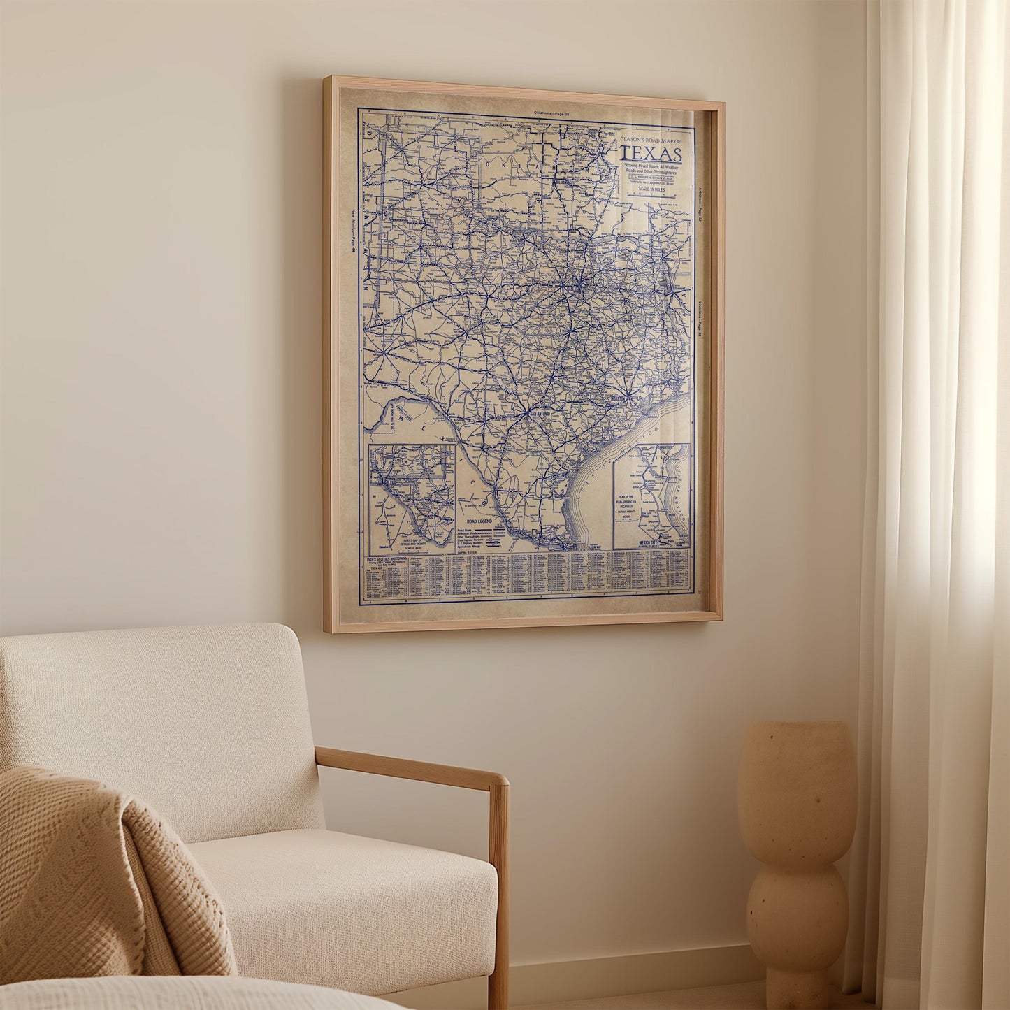 a framed map of Texas hanging on a wall in a room with a white sofa and a small sculpture.