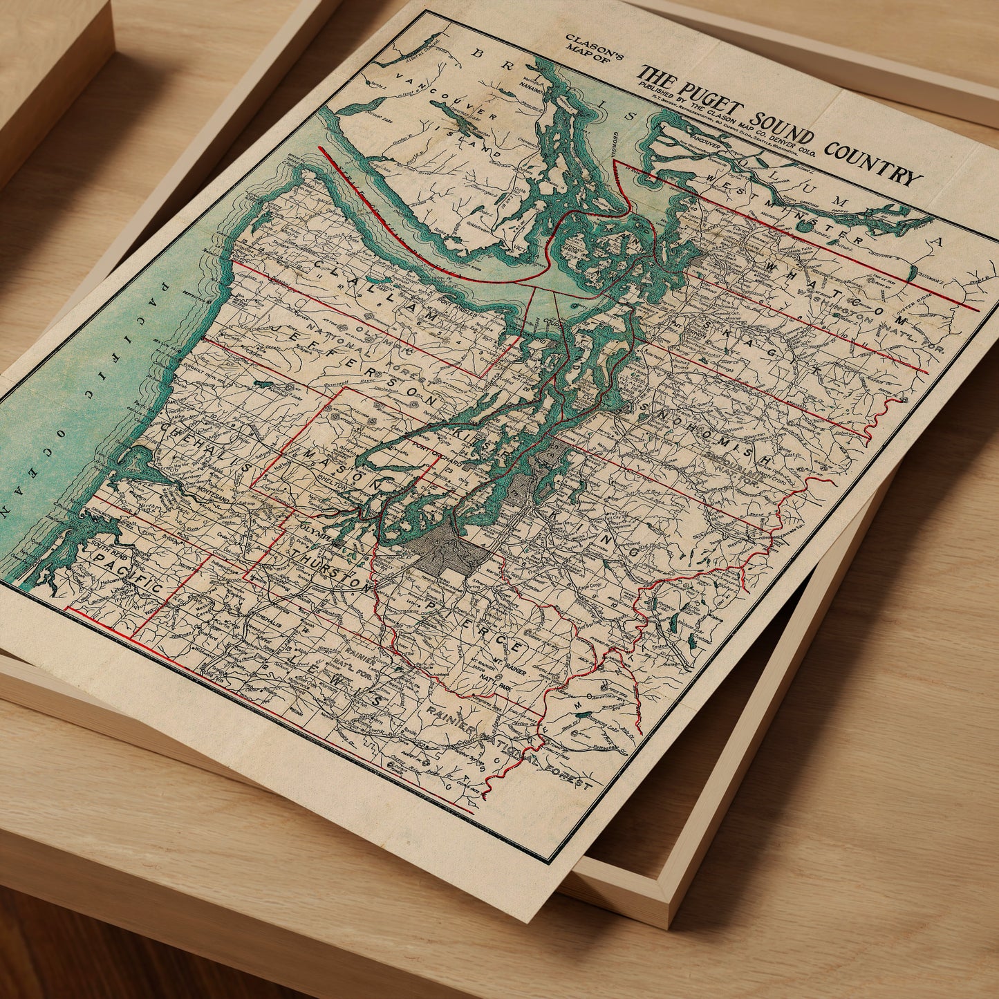 The image is a vintage map of the Puget Sound Country, depicting the region in a detailed and intricate manner.