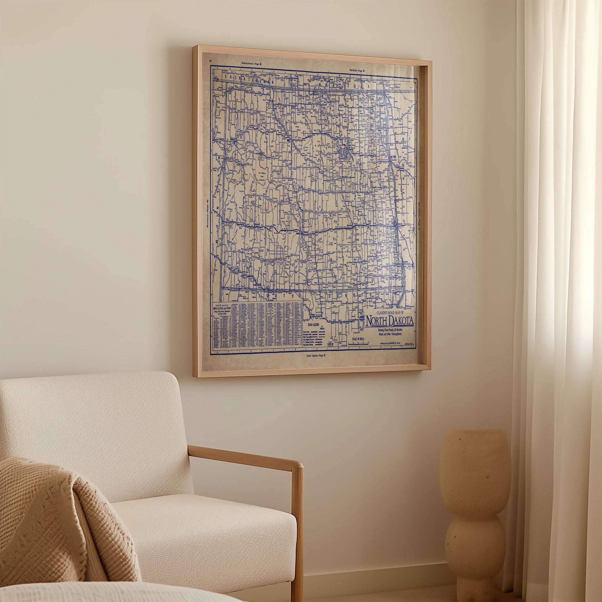 a large framed map of North Dakota hanging on a wall in a room with a white sofa and a small vase.