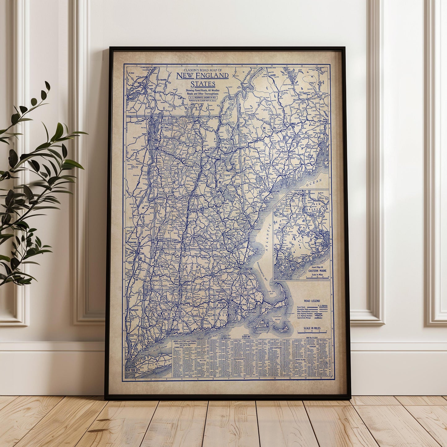 a framed vintage map of New England, including Connecticut, Rhode Island, Massachusetts, and New Hampshire, with a detailed road network and various geographical features.